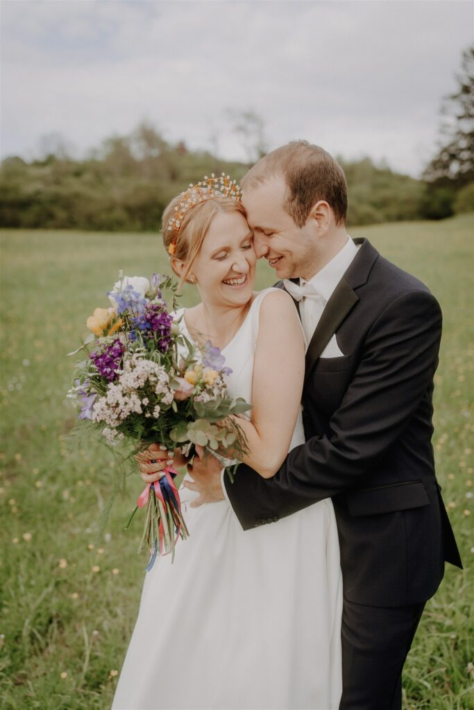 Hochzeitspaar auf Wiese, umarmen sich, Fotografiert von Hochzeitsfotograf in Metzingen, Reutlingen und Stuttgart